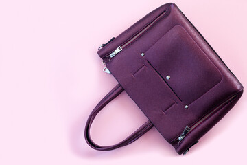 Beautiful leather purple handbags on pink paper background  in zine style.