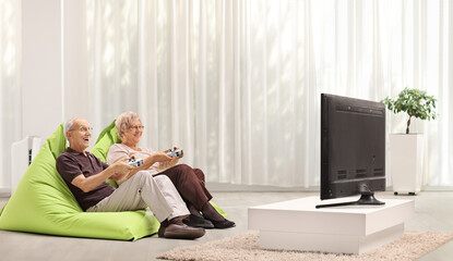 Elderly couple playing video games in front of tv