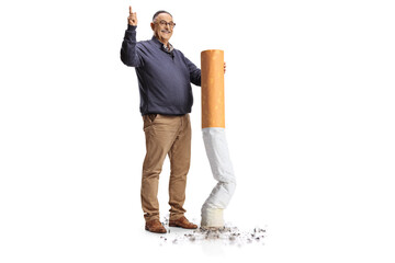 Full length portrait of a happy mature man putting off a big cigarette and pointing up