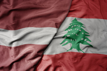 big waving national colorful flag of lebanon and national flag of latvia.