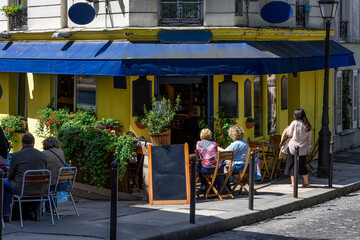 Cozy street with tables of cafe in quarter Montmartre in Paris, France. Architecture and landmark of Paris. Cozy Paris cityscape. - 751837772