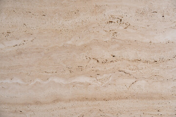 Detailed view of wood particle board with uneven texture with fibers and grains of compressed together. Lighter beige to darker brown structure with spots