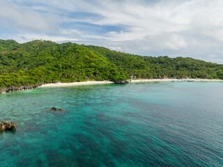 Greenish water with coral reefs and white sand beach. Cobrador Island. Romblon, Philippines.