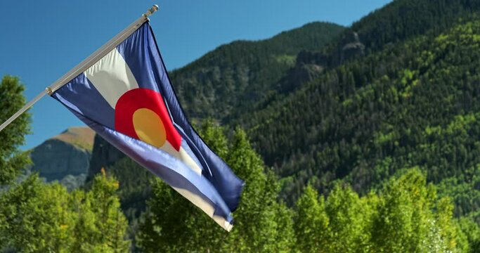 Colorado state flag waves in the Rocky Mountains wilderness