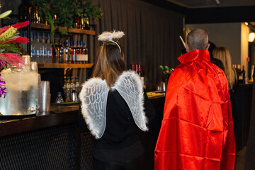 Angel and devil at a bar, costume party scene with elegant details and vibrant contrasts. Celebrating Purim in Israel.