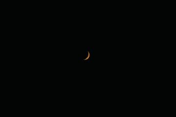 The darkened moon is yellow, eclipse. Crescent moon, moonlit sky, night, darkness. Phase, cycle, astronomy, astrology. Luna in the sky.