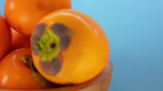 ripe persimmon in wooden plate