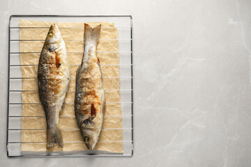 Baked fish on light marble table, top view. Space for text