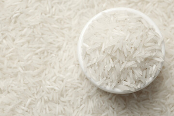 Raw basmati rice and bowl, top view. Space for text