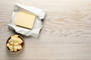 Tasty butter on light wooden table, flat lay. Space for text