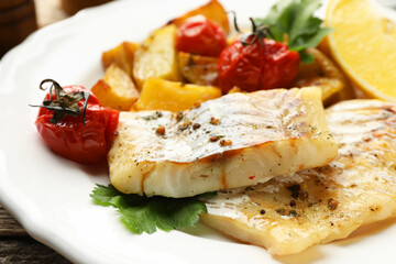 Tasty cod cooked with vegetables on table, closeup