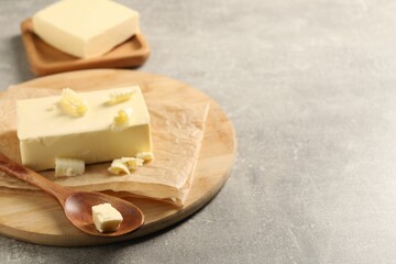 Block of tasty butter on grey table. Space for text