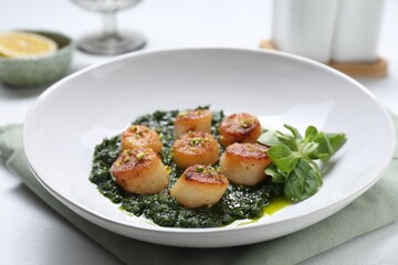 Delicious fried scallops with tasty sauce and corn salad in bowl on white table, closeup