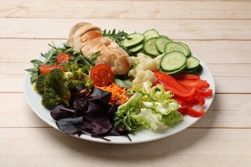 Balanced diet and healthy foods. Plate with different delicious products on wooden table