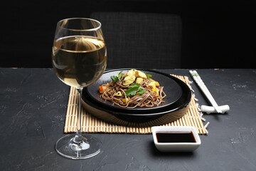 Stir-fry. Tasty noodles with meat and vegetables served on dark textured table