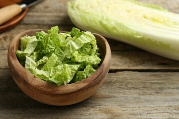 Cut fresh Chinese cabbage on wooden table, closeup - obrazy, fototapety, plakaty