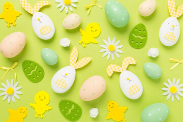 Easter eggs and decoration on color background, top view