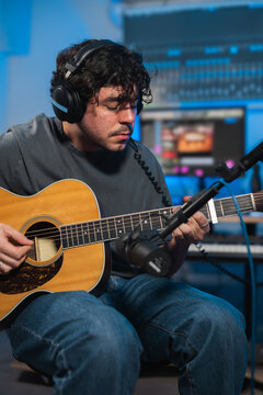 Musician Recording Acoustic Guitar in Studio