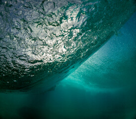 The underside of a powerful wave captured in exquisite detail, highlighting the textures and colors of the ocean's dynamic nature