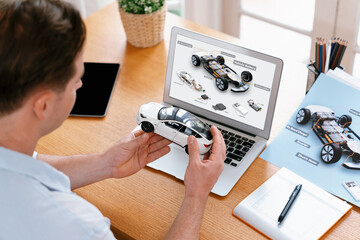 Car design engineer analyze car prototype for automobile business at home office. Automotive engineering designer carefully analyze, finding flaws and improvement for car model design. Synchronos - Powered by Adobe
