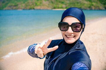 Muslim woman in burkini enjoying the beach