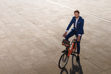 Portrait of latin businessman riding an electric bike at sunset. Sustainable lifestyle. Copy space.