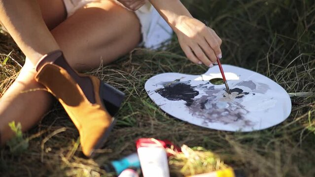 Woman sharing wood musical instrument event on grass with palette in hand