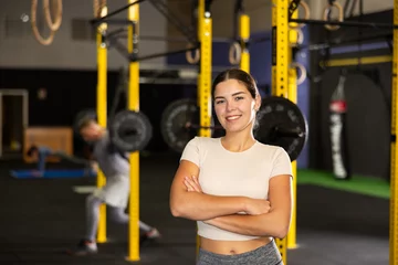 Foto op Plexiglas Young girl trainer in sportswear poses in fitness center gym. Active lifestyle, daily workouts in modern crossfit gym © JackF
