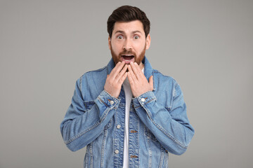 Portrait of surprised man on grey background