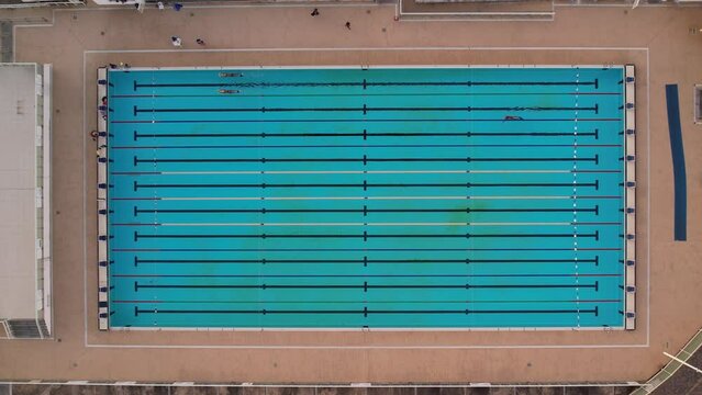 Olympic pool with three swimmers training in Salvador, Bahia, top view