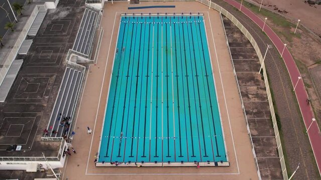 Olympic pool with three swimmers training in Salvador, Bahia, Aerial view