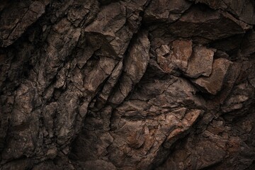 Black dark brown gray stone rock granite basalt texture background. Mountains surface. Close-up....