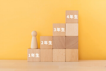 1年生、2年生、3年生、4年生の文字が入ったブロックと人形