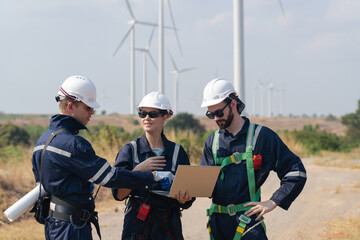 Engineers man and woman inspecting construction of WIND TURBINE FARM. WIND TURBINE with an energy storage system operated by Super Energy Corporation. Workers Meeting to check AROUND THE AREA.