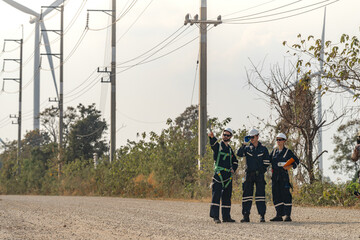 Engineers man and woman inspecting construction of WIND TURBINE FARM. WIND TURBINE with an energy storage system operated by Super Energy Corporation. Workers Meeting to check AROUND THE AREA.