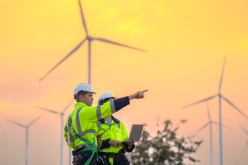 Team Engineers men and woman checking and inspecting on construction with sunset sky. people operation. Wind turbine for electrical of clean energy and environment. Industrial of sustainable.