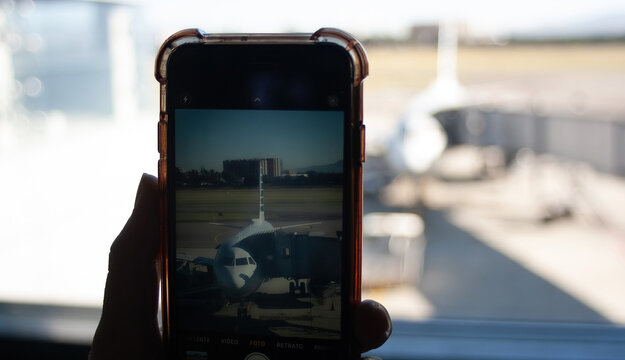 Passenger taking a picture of the plane about to leave with his mobile phone