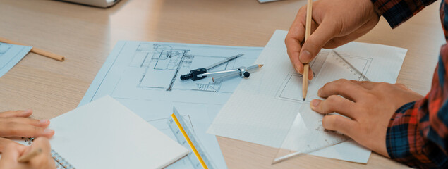 Professional architect hand drawing a blueprint by using ruler measuring length on table with...