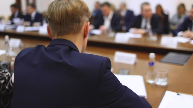 Group of men in business suits talking and discussing at conference, politicians and entrepreneurs debate, networking and negotiate, businessmen have dialog conversation on a forum, panel discussion