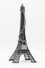 Miniatura de torre Eiffel cerrada con cadena y candado, aislado en blanco