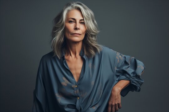 Portrait of a beautiful mature woman with grey hair and blue shirt.