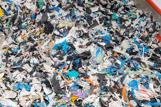 Shredded fragments of plastic waste of various colors. Waste material ready for reuse in production processes. Recycling and ecology