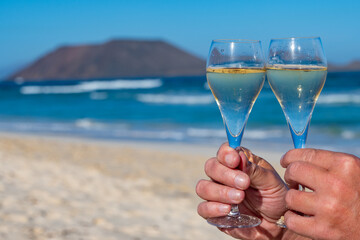 Pouring a glass of champagne on vacation, south of Fuerteventura, Canary islands, blue ocean,...