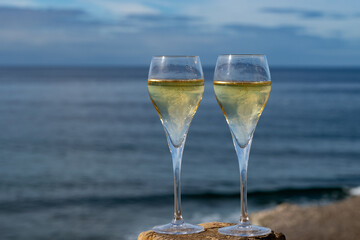 Pouring a glass of champagne on vacation, south of Fuerteventura, Canary islands, blue ocean, mountains
