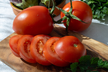 Ripe red Roma tomatoes in bowl with fresh herbs