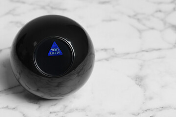 Magic eight ball with prediction Very Likely on white marble table, space for text