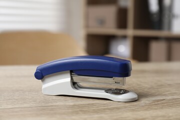 Bright stapler on wooden table indoors, closeup