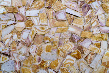 A wall made of stone with a pattern of brown and white stones