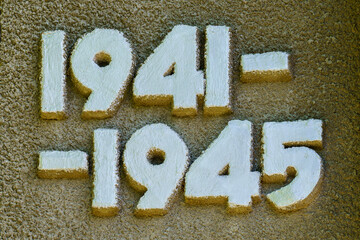 The numbers 1941 and 1945 are written in white on a brown surface - obrazy, fototapety, plakaty