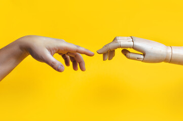 The hand of a robot,a golem,a mechanical man reaches out to the fingers of a real man.A parody of...
